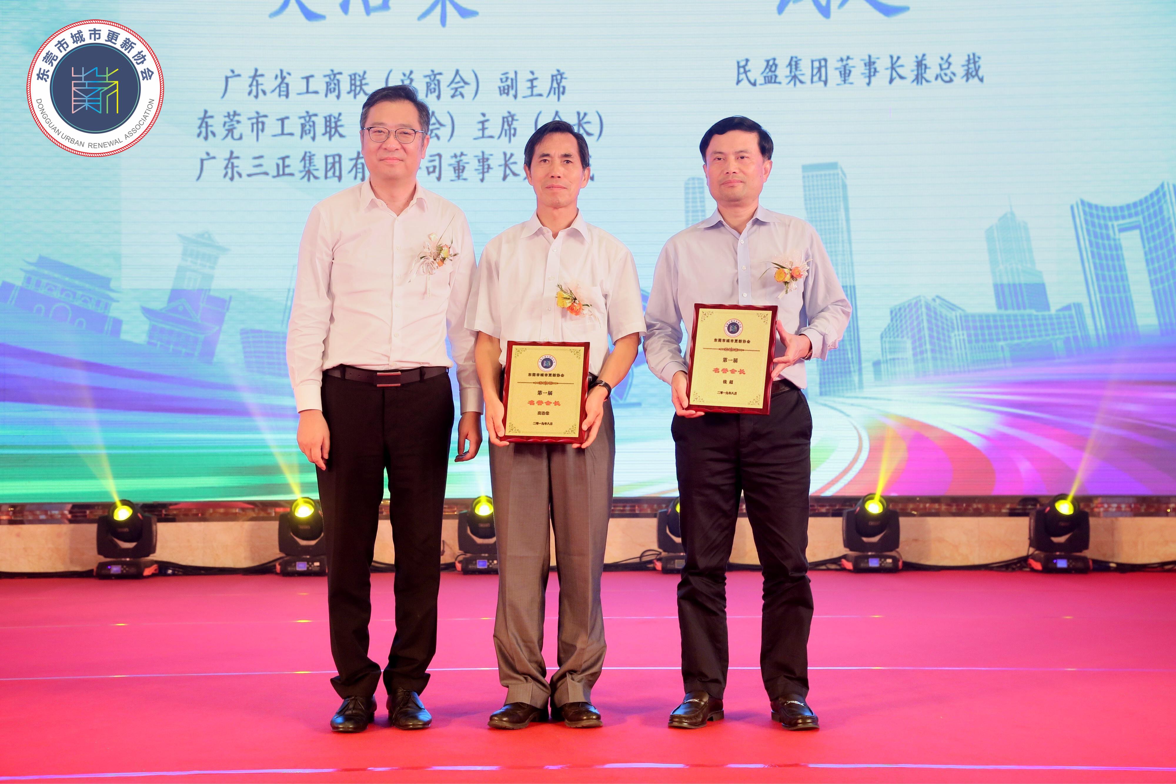 我集團(tuán)董事長(zhǎng)兼總裁莫浩棠（中）、民盈集團(tuán)董事長(zhǎng)兼總裁錢(qián)超（右）均被授予東莞市城市更新協(xié)會(huì)“名譽(yù)會(huì)長(zhǎng)”稱號(hào)。.jpg